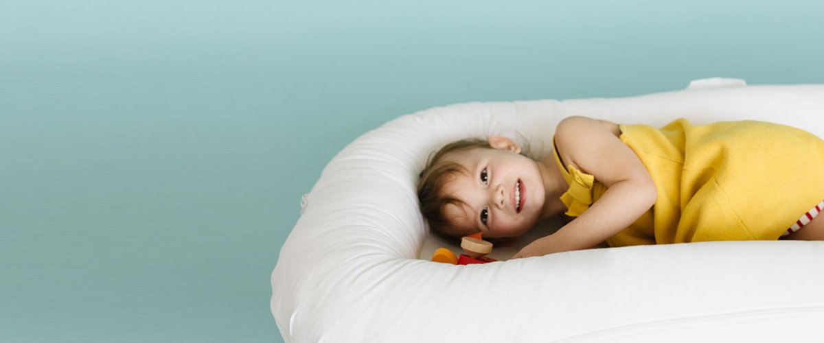 child lies in large sleepyhead grand pod